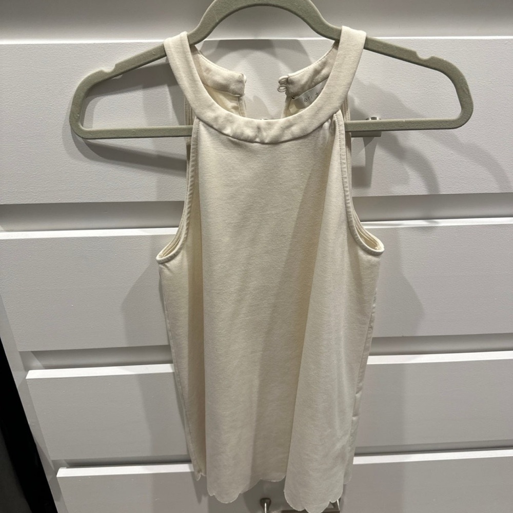 Off white tank top with round trim on the bottom